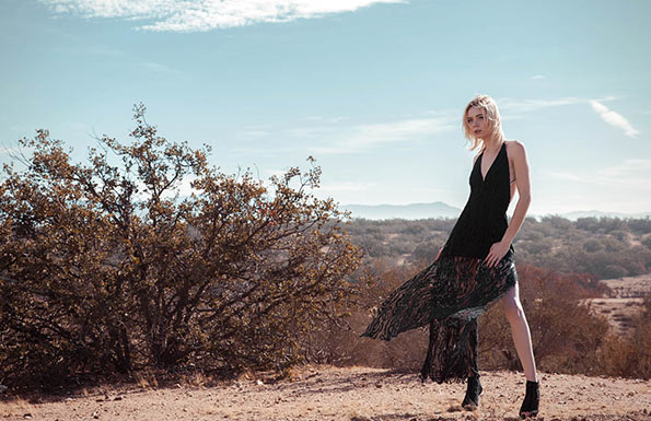 Woman in a long black dress in the desert